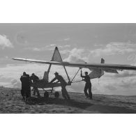 Des jeunes membres du Nationalsozialistischen Flieger-Korps (N.S.F.K.) acheminent un planeur léger sur son aire d'envol.