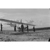 Des jeunes membres du Nationalsozialistischen Flieger-Korps (N.S.F.K.) acheminent un planeur léger sur son aire d'envol.