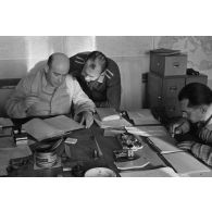 A Berlin, dans un bureau, des aviateurs de la Luftwaffe effectuent un travail administratif.