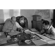A Berlin, dans un bureau, des aviateurs de la Luftwaffe effectuent un travail administratif.
