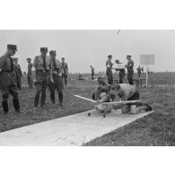 Deux membres des Hitlerjugend dont au moins un appartenant au district "Süd Franken", installent leur modèle réduit d'avion sur son aire d'envol, aidés par un cadre du N.S.F.K.