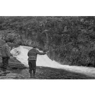Des officiers de la Luftwaffe pèchent dans un cours d'eau montagneux en Finlande.