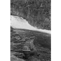 Des officiers de la Luftwaffe pèchent dans un cours d'eau montagneux en Finlande.