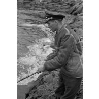 Des officiers de la Luftwaffe pèchent dans un cours d'eau montagneux en Finlande.