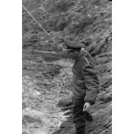 Des officiers de la Luftwaffe pèchent dans un cours d'eau montagneux en Finlande.