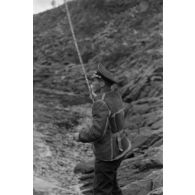Des officiers de la Luftwaffe pèchent dans un cours d'eau montagneux en Finlande.