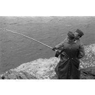 Des officiers de la Luftwaffe pèchent dans un cours d'eau montagneux en Finlande.