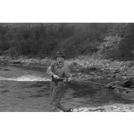 Des officiers de la Luftwaffe pèchent dans un cours d'eau montagneux en Finlande.