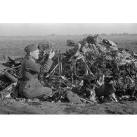 Un caméraman membre d'une compagnie de propagande de la Luftwaffe filme des débris provenant d'un avion abattu.