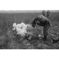 Cadavre d'un pilote soviétique, gisant sur le sol à côté de son parachute en torche.