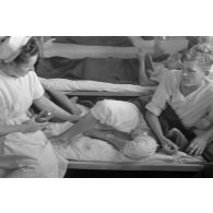 Une infirmière soigne la jambe d'un patient.