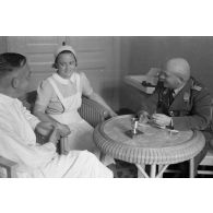 Un médecin et une infirmière discutent avec un capitaine (Hauptmann) de la Luftwaffe, peut-être un membre d'une compagnie de propagande.