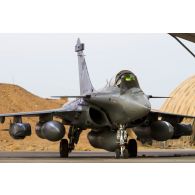 Un avion Rafale de l'escadron de chasse 3/30 Lorraine se tient prêt au décollage sur la piste de la base aérienne projetée (BAP) en Jordanie.