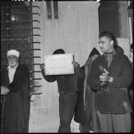 A l'entrée de la Casbah le ministre de la défense nationale, andré Morice, est applaudi par la foule musulmane et un jeune musulman présente un carton de bienvenue.