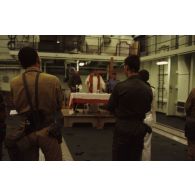 Messe célébrée à bord du TCD (transport de chalands de débarquement) Foudre, dans un hangar du pont d'envol, par un aumônier légionnaire et deux aumôniers du bord, un catholique et un protestant.