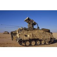 En ZDO (zone de déploiement opérationnel) Olive, un blindé M901 américain aux flancs recouverts par un filet de camouflage.