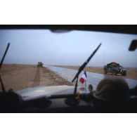 Par un temps pluvieux, l'axe Texas vu à travers le pare-brise d'un Peugeot P4.