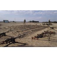 Des armes irakiennes récupérées, fusils d'assaut AK-47 ou AKM, et mitrailleuses PKMS et PKM de 7,62 mm, sont alignées au sol.