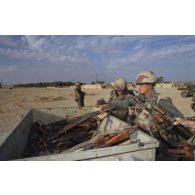Des marsouins du 2e RIMa (régiment d'infanterie de marine) chargent des armes irakiennes récupérées, fusils d'assaut AK-47 ou AKM, dans une remorque, aux abords d'Al Salman.