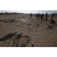 Des armes irakiennes récupérées, fusils d'assaut AK-47 ou AKM, sont alignés au sol aux abords d'Al Salman. En arrière-plan des marsouins du 2e RIMa (régiment d'infanterie de marine) s'affairent à les charger dans une remorque.