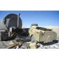 Blindés et camions irakiens détruits ou abandonnés à la sortie de Koweit City : un blindé de reconnaissance BRDM-2, une voiture et un camion-citerne encastrés.