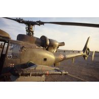 Au soir un hélicoptère de combat Gazelle Atam armé de missiles Mistral au sol dans le désert.