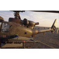 Au soir un hélicoptère de combat Gazelle Atam armé de missiles Mistral au sol dans le désert.