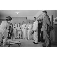 Le caméraman Herbert Lander prépare sa caméra tchèque Cinephon 35 pour immortaliser la visite par les commandants de U-Boot de l'exposition de peintres de guerre à l'hôtel Royal de La Baule.