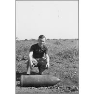 Robert Pila près d'un obus. [légende d'origine]