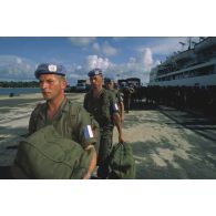 Les militaires du bataillon français portent leur paquetage à leur arrivée au port de Sihanoukville.