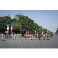 Défilé des gardes au drapeau burkinabè et béninoises sur les Champs-Elysées, à Paris.
