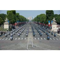 Le lieutenant-colonel Jean-Pierre Reynaud et le capitaine Yannick défilent en tête des escadrons motocyclistes du centre national de formation à la sécurité routière de la gendarmerie et de la Police nationale sur les Champs-Elysées, à Paris.