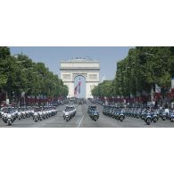 Le lieutenant-colonel Jean-Pierre Reynaud et le capitaine Yannick défilent en tête des escadrons motocyclistes du centre national de formation à la sécurité routière de la gendarmerie et de la Police nationale sur les Champs-Elysées, à Paris.