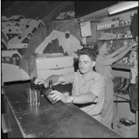 Portrait de deux appelés du contingent des classes 58 2/B et 57 2/A derrière le bar, originaires de Incheville en Seine-Maritime et de Rosendaël dans le Nord, ouvrier et aide-comptable dans le civil.
