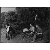 Libération de la Corse. Un opérateur radio transmet un message sur un poste émetteur-récepteur, sous la protection de résistants corses équipés de pistolets-mitrailleurs Sten Mk II.