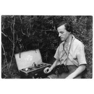 Libération de la Corse. Un opérateur radio émet un message sur un poste émetteur-récepteur (valise radio) dans le maquis corse.