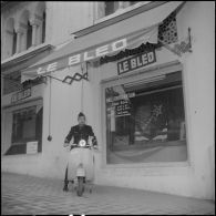 Un aviateur devant le siège du journal Le Bled à Alger avec son scooter. [Description en cours]