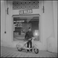 Un aviateur devant le siège du journal Le Bled à Alger avec son scooter. [Description en cours]