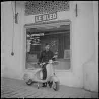 Un aviateur devant le siège du journal Le Bled à Alger avec son scooter. [Description en cours]