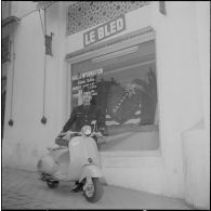 Un aviateur devant le siège du journal Le Bled à Alger avec son scooter. [Description en cours]