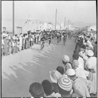 Colomb-Béchar. Festivités du 14 Juillet 1960 dans la zone ouest sud (ZOS). Sur 8 kilomètres de parcours la foule compacte attend le passage du "Tour de Bechar".