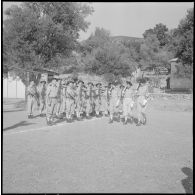 Le fanion du 27e bataillon de chasseurs alpins (27e BCA) passe devant les chasseurs au présenter arme.