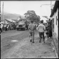 Montées sur camions Molotova, les troupes vietminh font leur entrée à Campha sous le regard de la population.