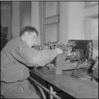 Air de France. Ecole militaire annexe des Transmissions d'Afrique du Nord (EMAT/AFN). Un élève étudie un lot de transmetteur et récepteur télégraphique.