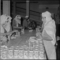 Relizane. Confiturerie Escla. Etiquetage des boîtes de confiture à la main et à la machine.