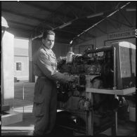 Camp de l'Alma. Centre d'instruction du service du matériel n°3 (CISM 3). Portrait d'un stagiaire devant un moteur.