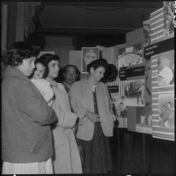 Alger. Hall du journal Le Bled. Exposition "Activités et loisirs". Des femmes regardent les panneaux concernant la chorale, les orchestres et la fanfare.