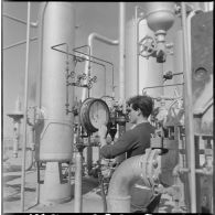 Région d'Edjeleh. Exploitations pétrolières sahariennes. Un ouvrier vérifie des oléoducs.