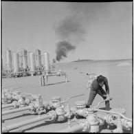 Région d'Edjeleh. Exploitations pétrolières sahariennes. Un ouvrier actionne des vannes des oléoducs.