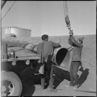 Région d'Edjeleh. Exploitations pétrolières sahariennes. Des ouvriers travaillent sur un oléoduc.